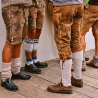Mehrere Männerbeine in Lederhosen und Wadenstrümpfen.