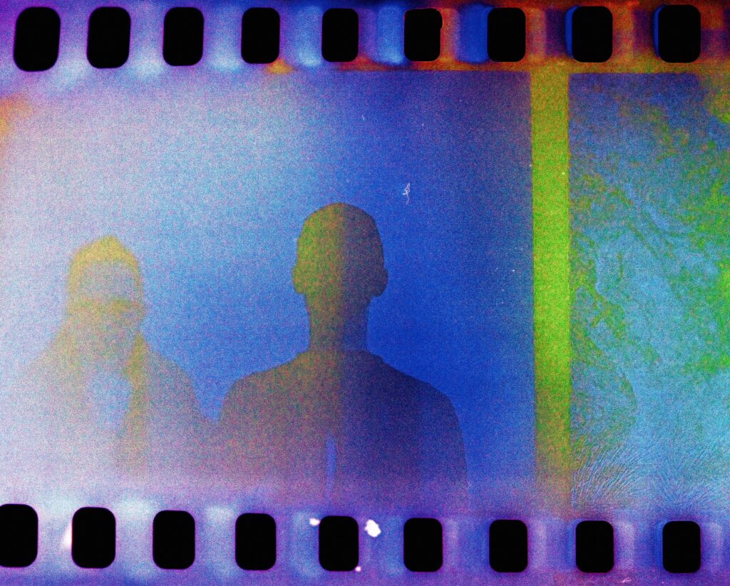 Bunter Filmstreifen mit Silhouetten zweier Menschen